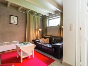 uma sala de estar com um sofá de couro e uma mesa em This accommodation is full of atmosphere and on a beautiful estate em Zedelgem