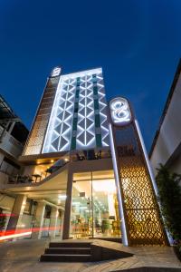 un edificio con una señal delante de él en The 8 Hotel Udonthani en Udon Thani