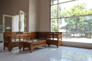 a living room with benches and a large window at RedDoorz Syariah near Balai Kota Probolinggo 2 in Probolinggo
