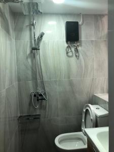 a bathroom with a shower with a toilet and a sink at Cebu Hostel in Hong Kong