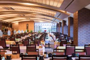 New Welcity Yugawara في أتامي: غرفة طعام كبيرة مع طاولات وكراسي