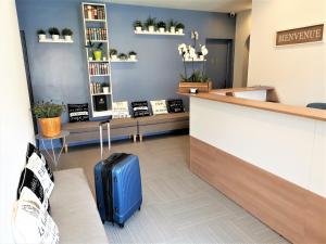 a blue suitcase sitting in the lobby of a store at Hotel L'Escapade in Le Lavandou