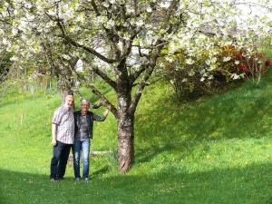 Ein Mann und eine Frau stehen neben einem Baum in der Unterkunft Ferienwohnung Eichler in Feldkirchen in Kärnten