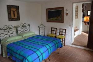 a bedroom with a bed with a blue and green blanket at Ammiraglio - Villa Ziri in Giglio Porto