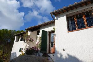 a white house with green shutters and a window at Ammiraglio - Villa Ziri in Giglio Porto