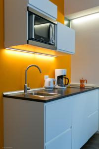 a kitchen with a sink and a microwave at Apartment Vanga in Bolzano