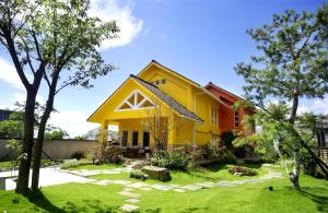 a yellow house with a yard at The Dew B&B in Dongshan