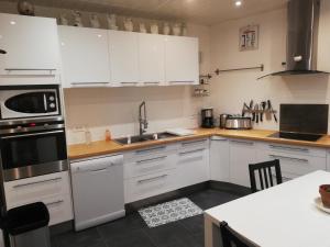 a kitchen with white cabinets and a stove top oven at L'Escale Bellevue in Blaye