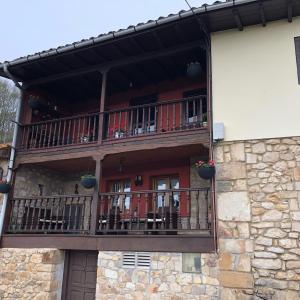 a building with a balcony with tables and chairs at los Balcones de Nieda in Cangas de Onís
