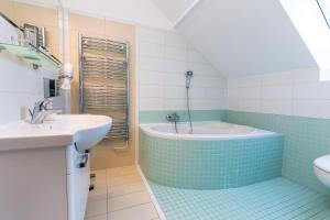 uma casa de banho com uma banheira e um lavatório em Attic Apartment by Wenceslas Square em Praga