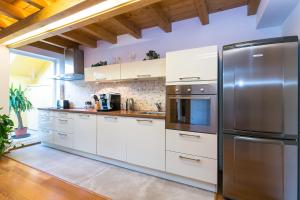 uma cozinha com armários brancos e um frigorífico de aço inoxidável em Attic Apartment by Wenceslas Square em Praga