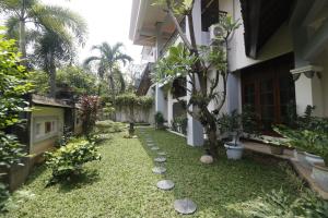 蘇達約縣的住宿－RedDoorz Syariah near Gelora Delta Sidoarjo，庭院中有一棵树的房子的庭院