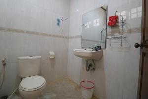 蘇達約縣的住宿－RedDoorz Syariah near Gelora Delta Sidoarjo，白色的浴室设有卫生间和水槽。