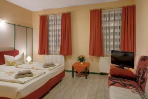 a hotel room with two beds and a flat screen tv at Pension Haus Saarland in Oberhof