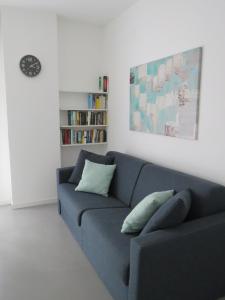a living room with a blue couch and a book shelf at Assago Forum Apartment in Assago