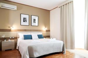 a bedroom with a large white bed with blue pillows at Pegasus Hotel in Sassari