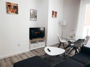 a living room with a tv and a table at Alicante Center Apart in Alicante