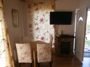 a dining room with a table and chairs and a television at Lipót-Haus in Lipót