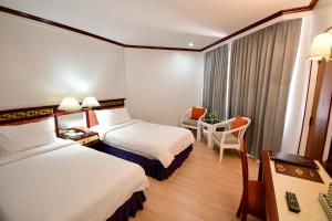 Rúm í herbergi á Wangcome Hotel
