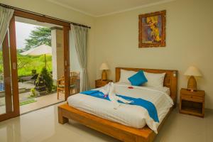 a bedroom with a bed and a sliding glass door at The Carik Bisma Ubud in Ubud