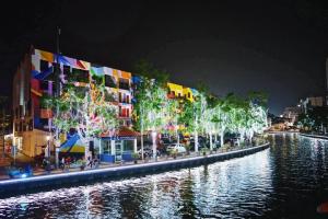 een gebouw met kerstverlichting naast een rivier 's nachts bij 906 Riverside Hotel Malacca in Melaka