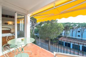 een balkon met een tafel en stoelen en uitzicht op een gebouw bij AY-3 CALELLA DE PALAFRUGELL, 4 PaX in Calella de Palafrugell