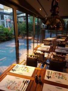 restauracja ze stołami i krzesłami oraz dużym oknem w obiekcie Milord Hotel w Stambule