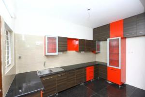 a kitchen with brown and orange cabinets and a sink at THE POSH RESIDENCY, ECR in Chennai