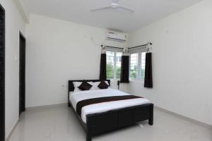 a bedroom with a black and white bed and windows at THE POSH RESIDENCY, ECR in Chennai