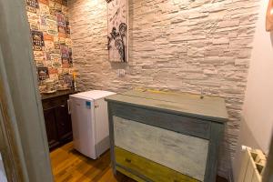 a bathroom with a stone wall and a white refrigerator at Garibaldi33 in Avezzano