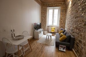 a living room with a couch and a table at Hamac Suites - Studio Ainay 4 - Hyper centre Lyon in Lyon