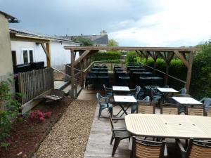 a row of tables and chairs on a patio at Logis Hôtel Restaurant L'Escale in Bellême