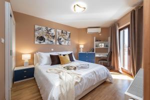 sypialnia z dużym białym łóżkiem i biurkiem w obiekcie Zen Luxury Apartments w mieście Zadar