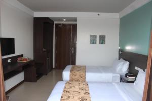 Habitación de hotel con 2 camas y TV en Kew Hotel Tagbilaran en Tagbilaran City