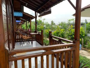 un porche de una casa con sillas y mesas en Tanah Penida Bungalows, en Nusa Penida