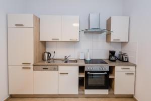 a kitchen with white cabinets and a sink at Leer Innenstadt 1 in Leer