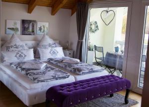 Dos camas en una habitación con un banco púrpura. en Ihre Auszeit am Golfplatz, en Meisdorf