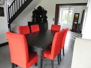 a dining room with a black table and red chairs at LA RENAUDIERE in Dancé