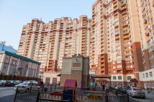 a large apartment building in front of a parking lot at Apartment on Kukolkina in Voronezh