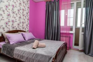 a pink bedroom with a bed with a towel on it at Apartment on Kukolkina in Voronezh