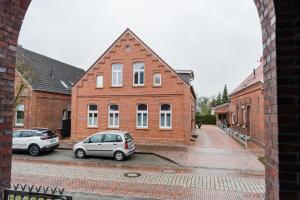 two cars parked in front of a brick building at Leer Innenstadt 1 in Leer