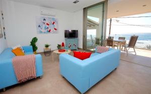 una sala de estar con 2 sofás azules y una mesa. en Apartamento s' Estanyol Mar, en El Estanyol