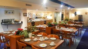 a restaurant with wooden tables and chairs and a counter at Hotel Am Düsseldorfer Platz in Ratingen