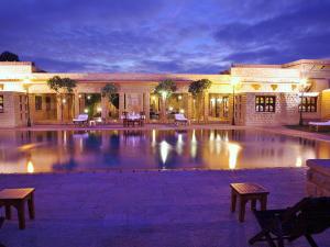 un gran edificio con piscina por la noche en Hotel Rawalkot Jaisalmer, en Jaisalmer