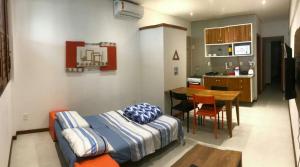 a bedroom with a bed and a table and a kitchen at Village Novo Praia do Forte 2 in Mata de Sao Joao