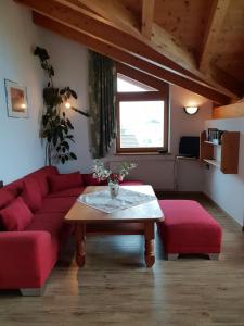 a living room with a red couch and a table at Piz Apart Raich in Arzl im Pitztal