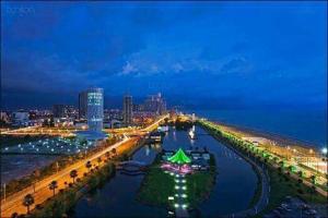 a view of a city with a river at night at Apartment ЖУЖУНА in Batumi