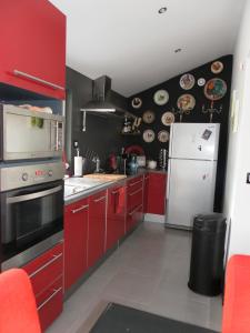 a kitchen with red cabinets and a white refrigerator at LA RENAUDIERE in Dancé