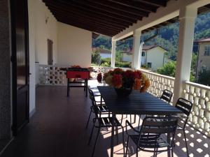 porche con mesa azul y sillas en el balcón en Villa Mara, en Riccò del Golfo di Spezia
