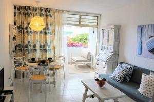 a living room with a couch and a table at Bougainvillea apartment Bamira in Maspalomas